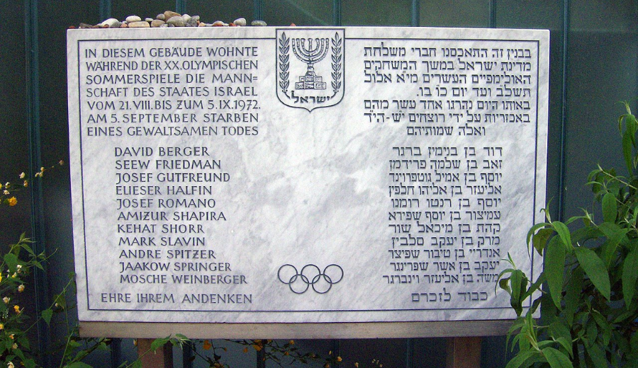 Memorial na frente dos quartos dos atletas israelenses. A inscrição, em alemão e hebraico, lê-se: A equipe do Estado de Israel permaneceu neste edifício durante os Jogos Olímpicos de Verão de 21 de agosto a 5 de setembro 1972. Em 5 de setembro, teve uma morte violenta. Honra de sua memória - Foto: Reprodução / Wikipédia